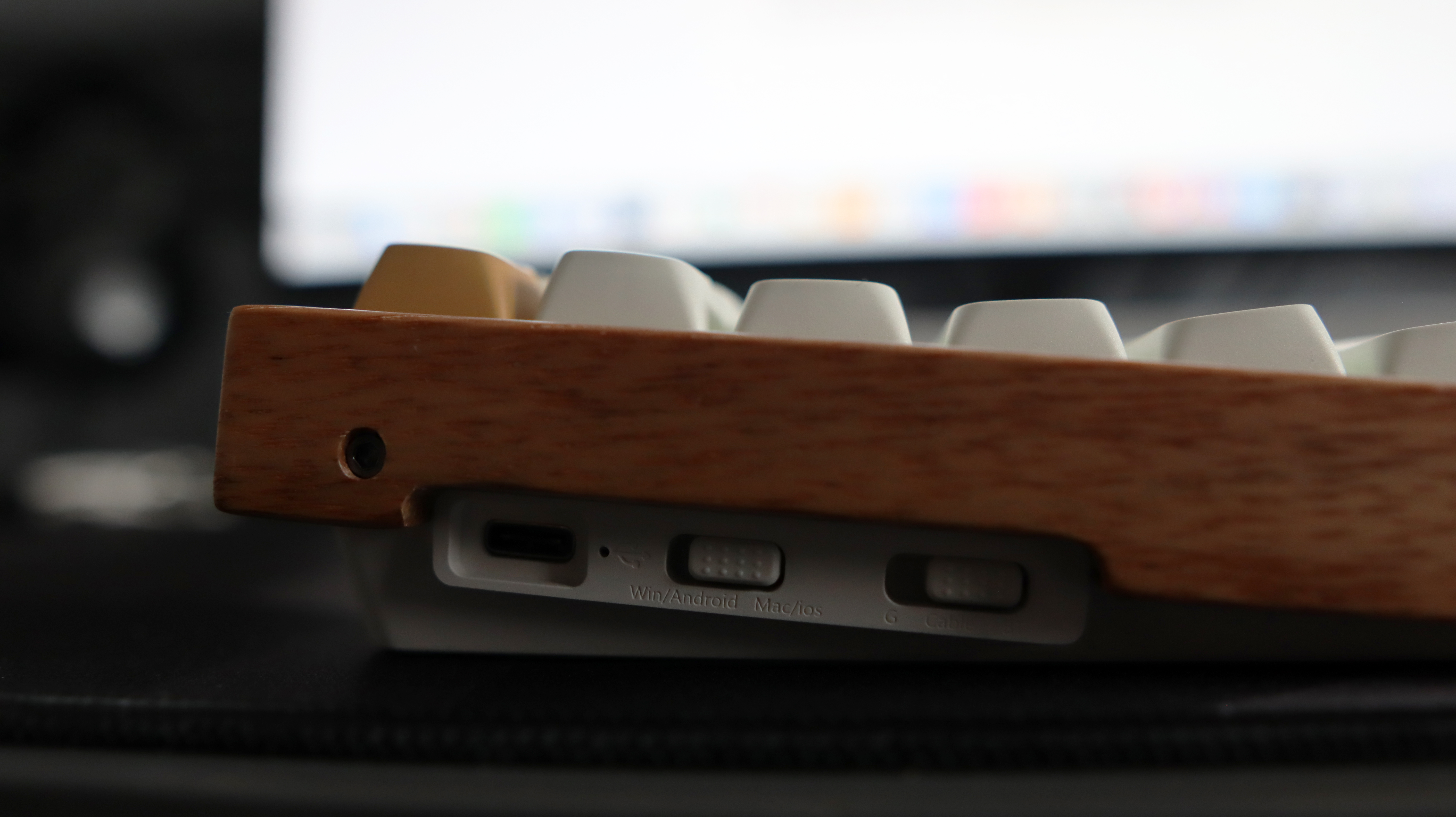 A Keychron K2 HE gaming keyboard with a wood finish and white keycaps with RGB enabled.