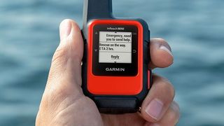 Garmin InReach Mini GPS satellite tracker held in hand