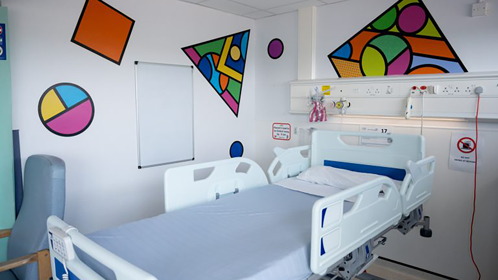 A hospital room decorated with wall art designed by the artist Supermundane