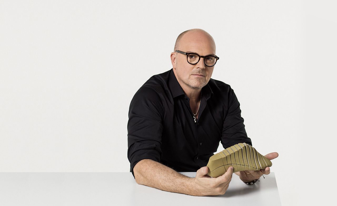 Nike Vice President, John Hoke holding a basic shoe prototype against a light coloured background