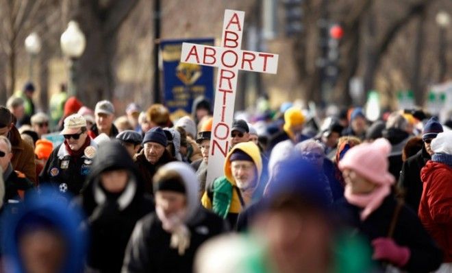 An anti-abortion demonstrator carries a giant sign in D.C..