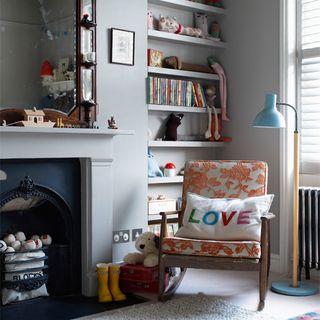 childrens room with grey wall and fireplace