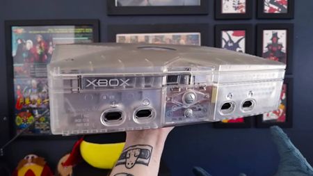 Arm holding up OG Xbox Crystal Edition.