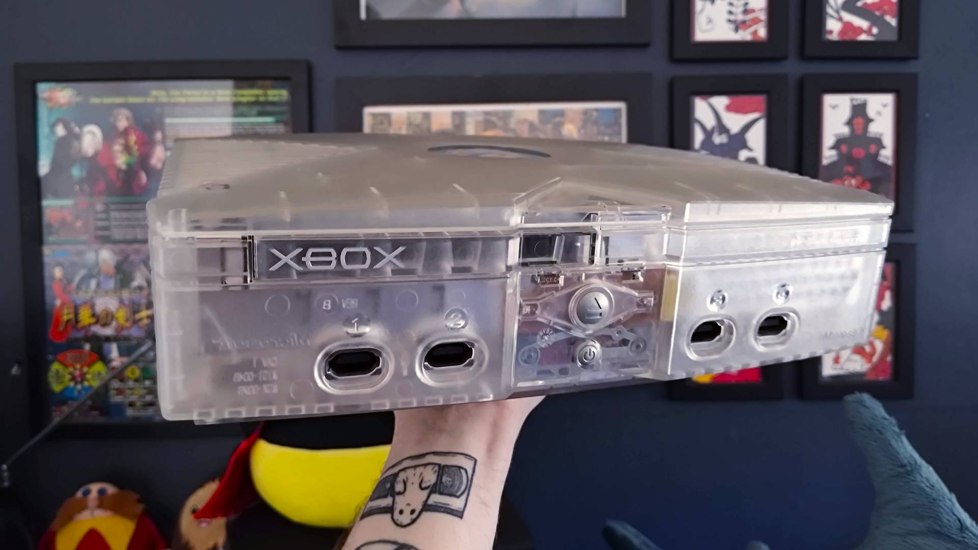 Arm holding up OG Xbox Crystal Edition.