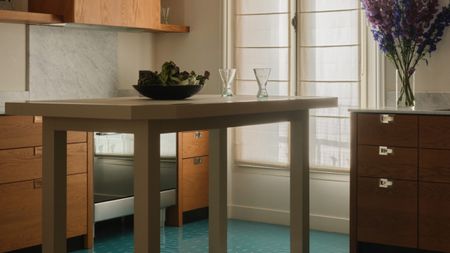 a wood kitchen with a turquoise floor and a tall island