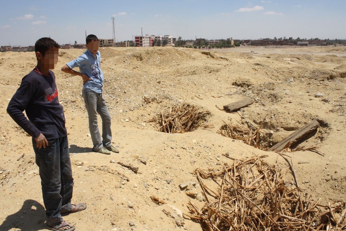 Two kids take a break at a heavily looted ancient cemetery at Abusir el-Malek, located south of Cairo.