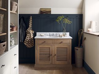 Cottage cloakroom with oak vanity unit and navy paneling