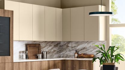 Neutral kitchen with upper cabinets in a pale beige and lower cabinets in a dark wood with a marble splash back