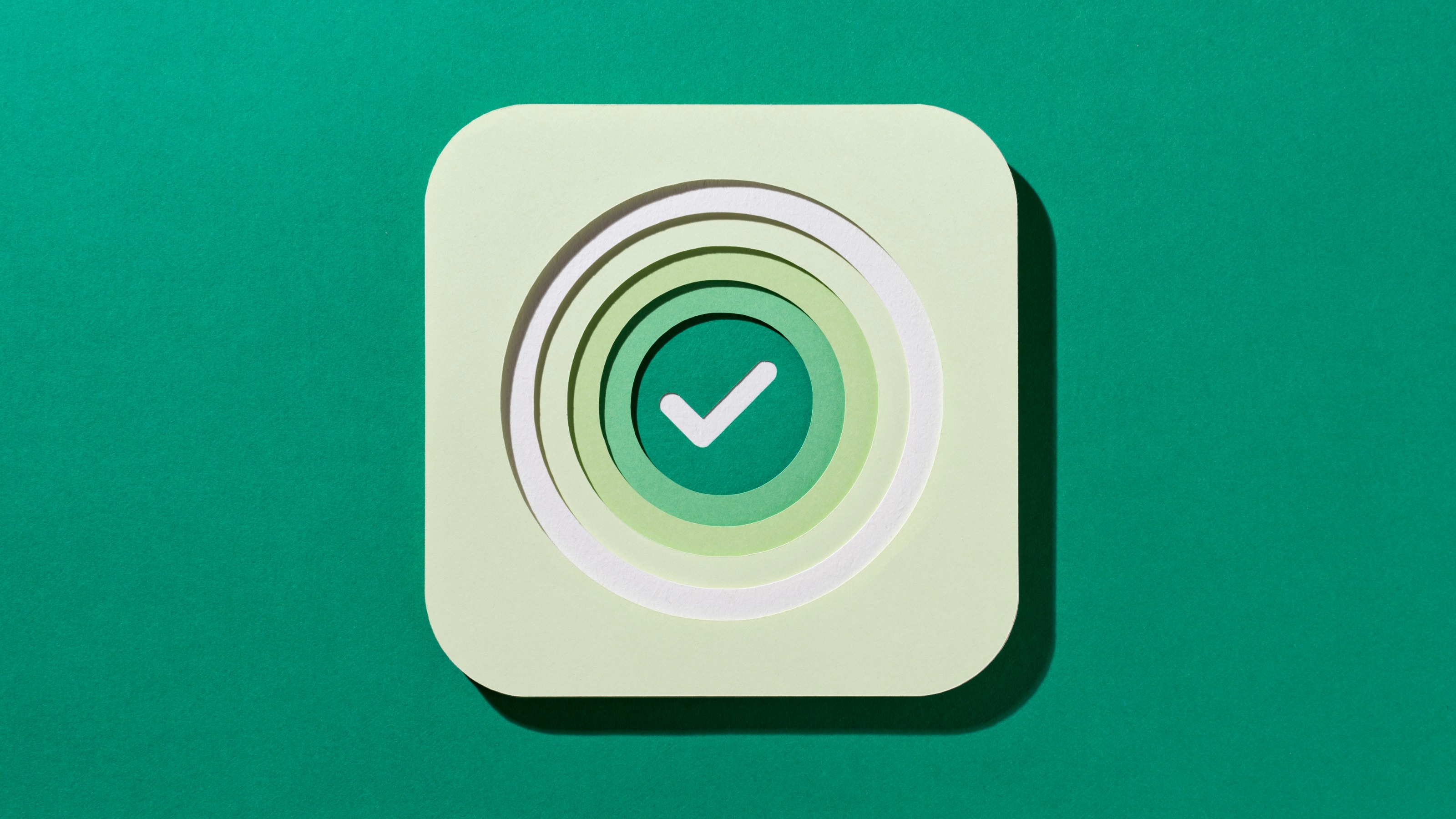 Multi Layered Paper Craft Green Color Check Mark in Concentric Circles on Green Background