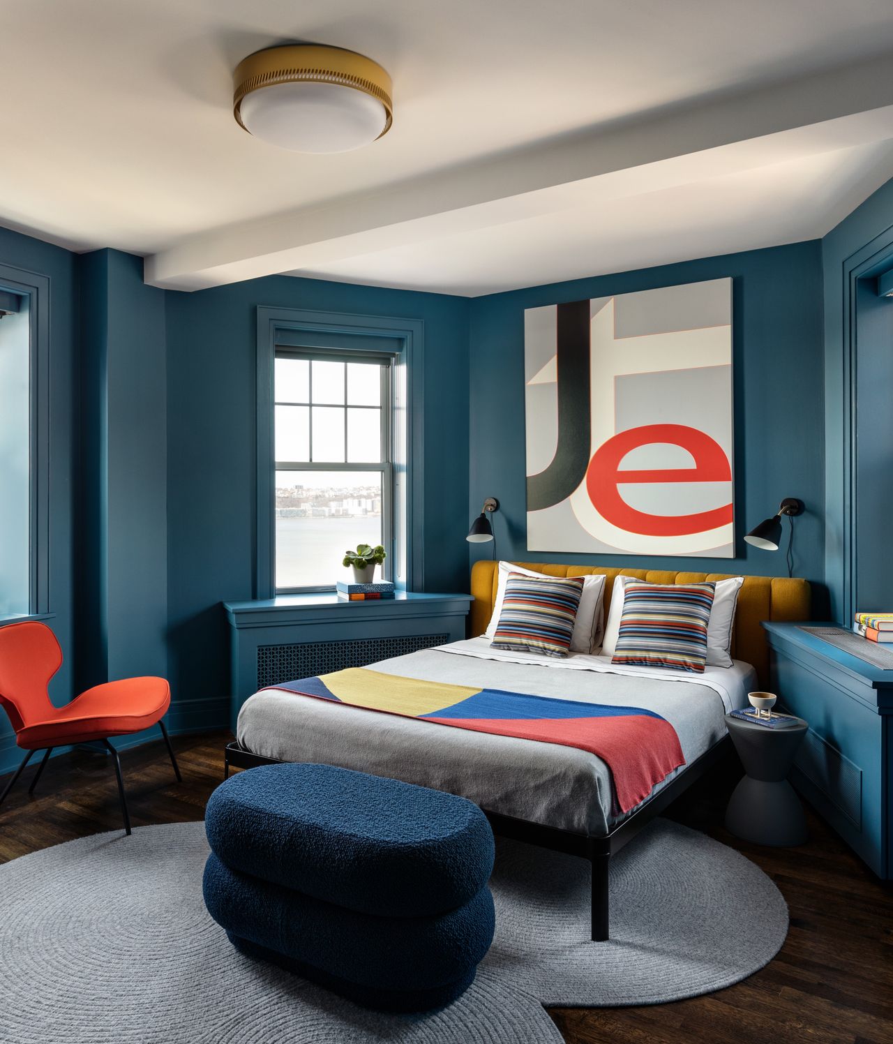 A small bedroom with a rug in concentric ciircles