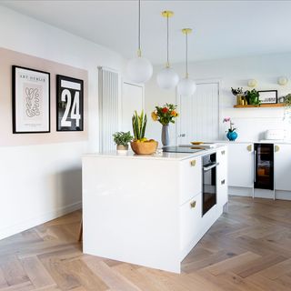 white kitchen with island and herringbone flooring