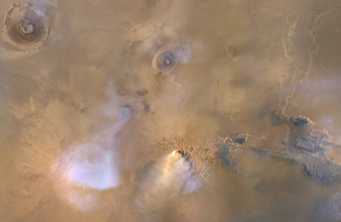 An image captured by NASA&#039;s Mars Reconnaissance Orbiter in 2010 shows a yellowish dust cloud with blueish-white plumes of water vapor.