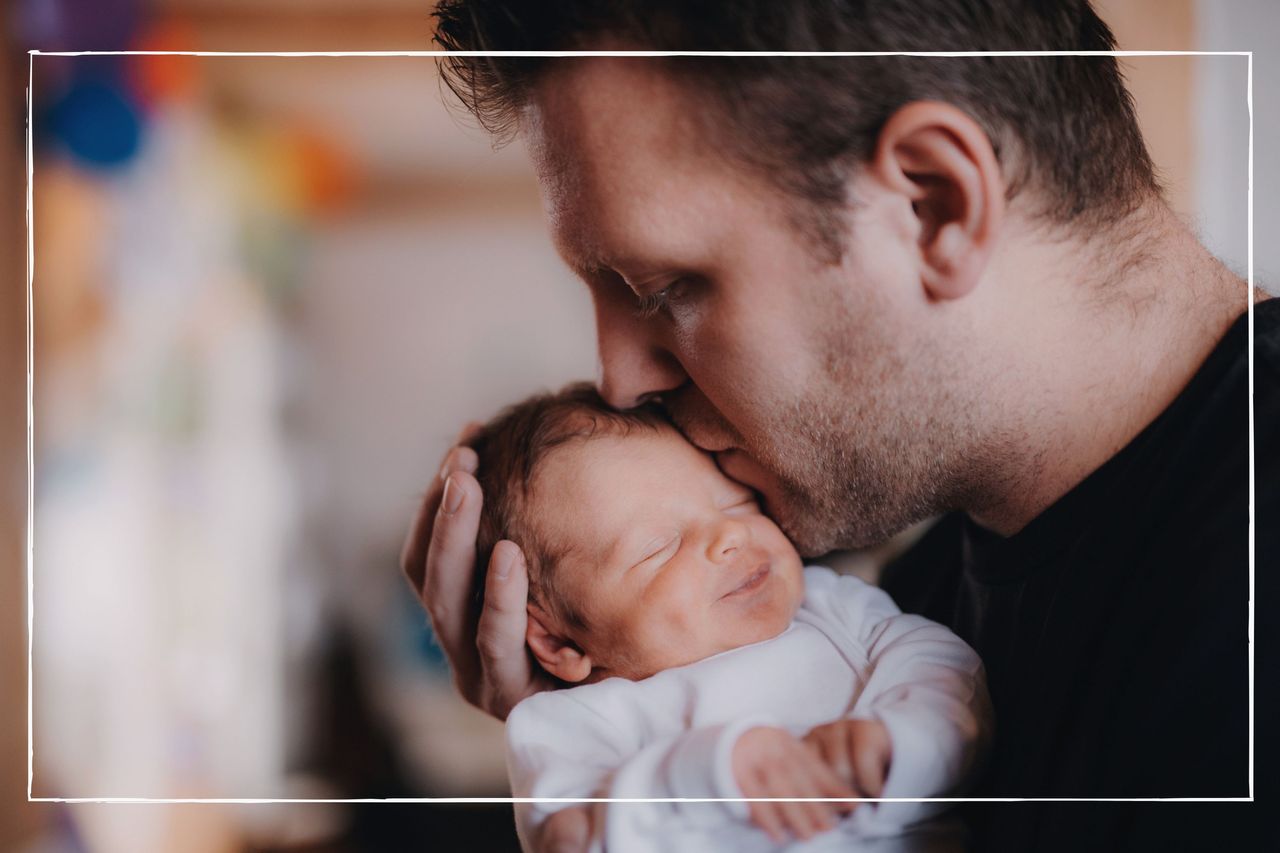 Father holding his newborn baby and kissing his head