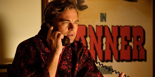 Once Upon A Time In Hollywood Rick takes a call in front of his poster