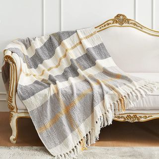 Woven throw blanket draped over a white sofa