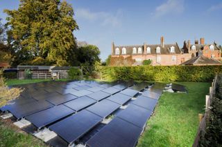 Solar panels in a field next to a listed building