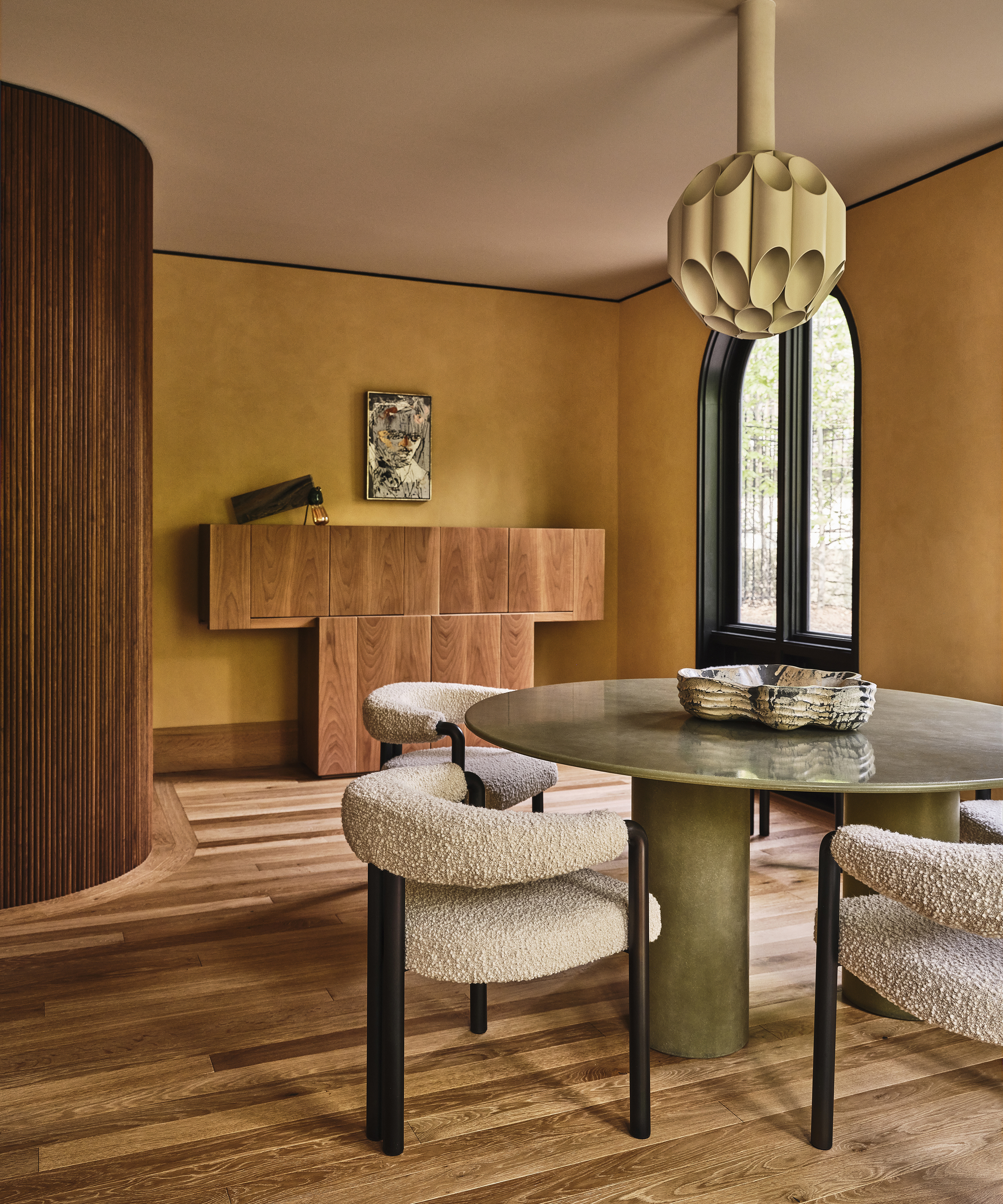 yellow dining room with round dining table and modern white chairs