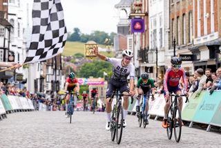 Riders finish a crit race in a town centre