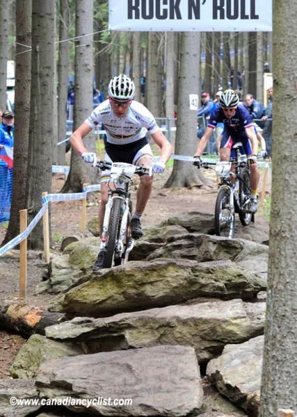 Victor Koretzky (Bikepark.ch Craft) and Titouan Carod (France) navigate through the slippery rocks