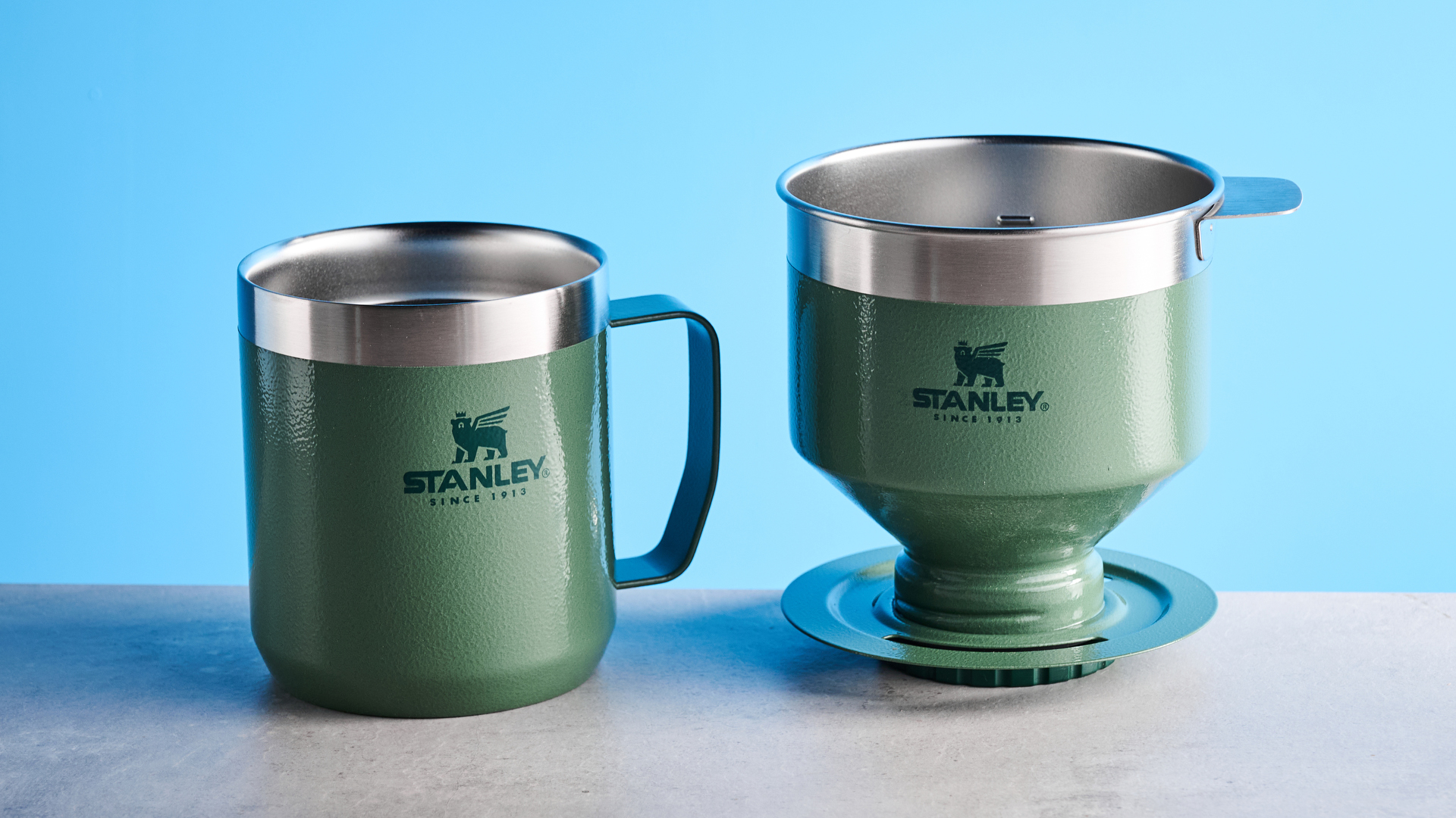 the stanley perfect brew pour over coffee maker in green, photographed with its companion travel mug and with the metal built in filter
