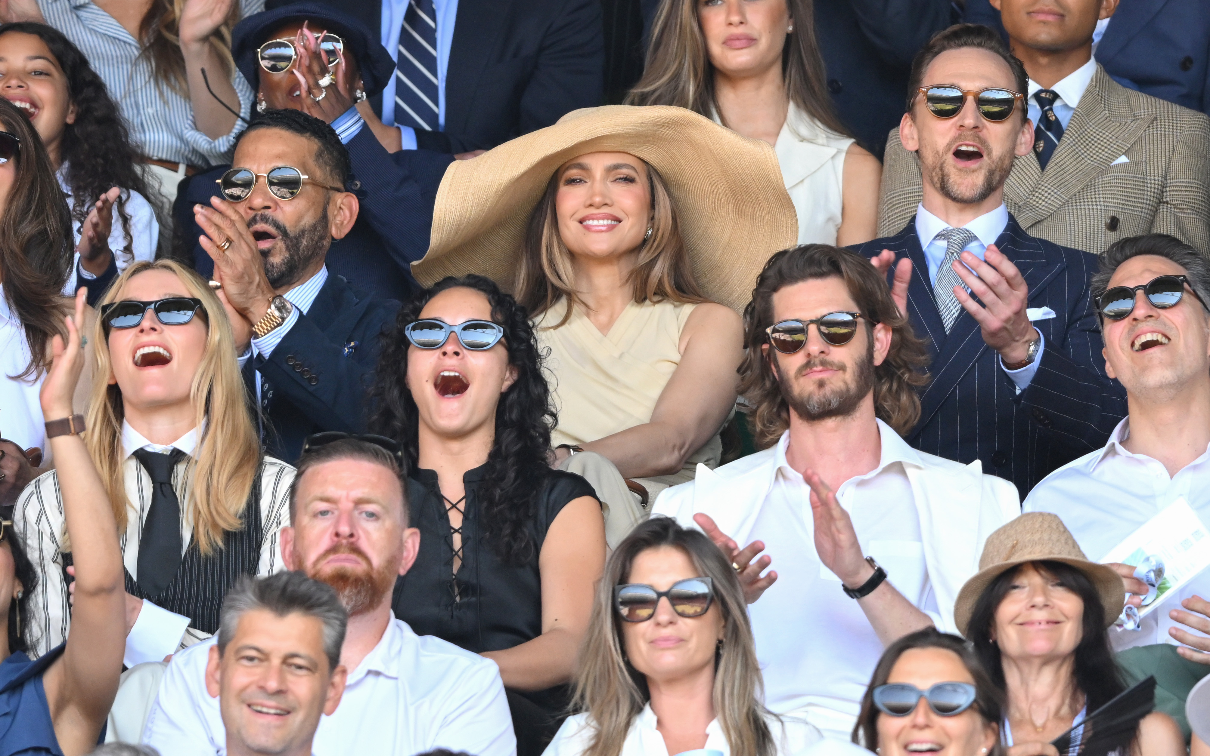 Jennifer Lopez attends Wimbledon on July 12, 2026 wearing a massive raffia hat and a dress from Ralph Lauren, joining Tom Hiddleston who wears a navy pinstripe suit