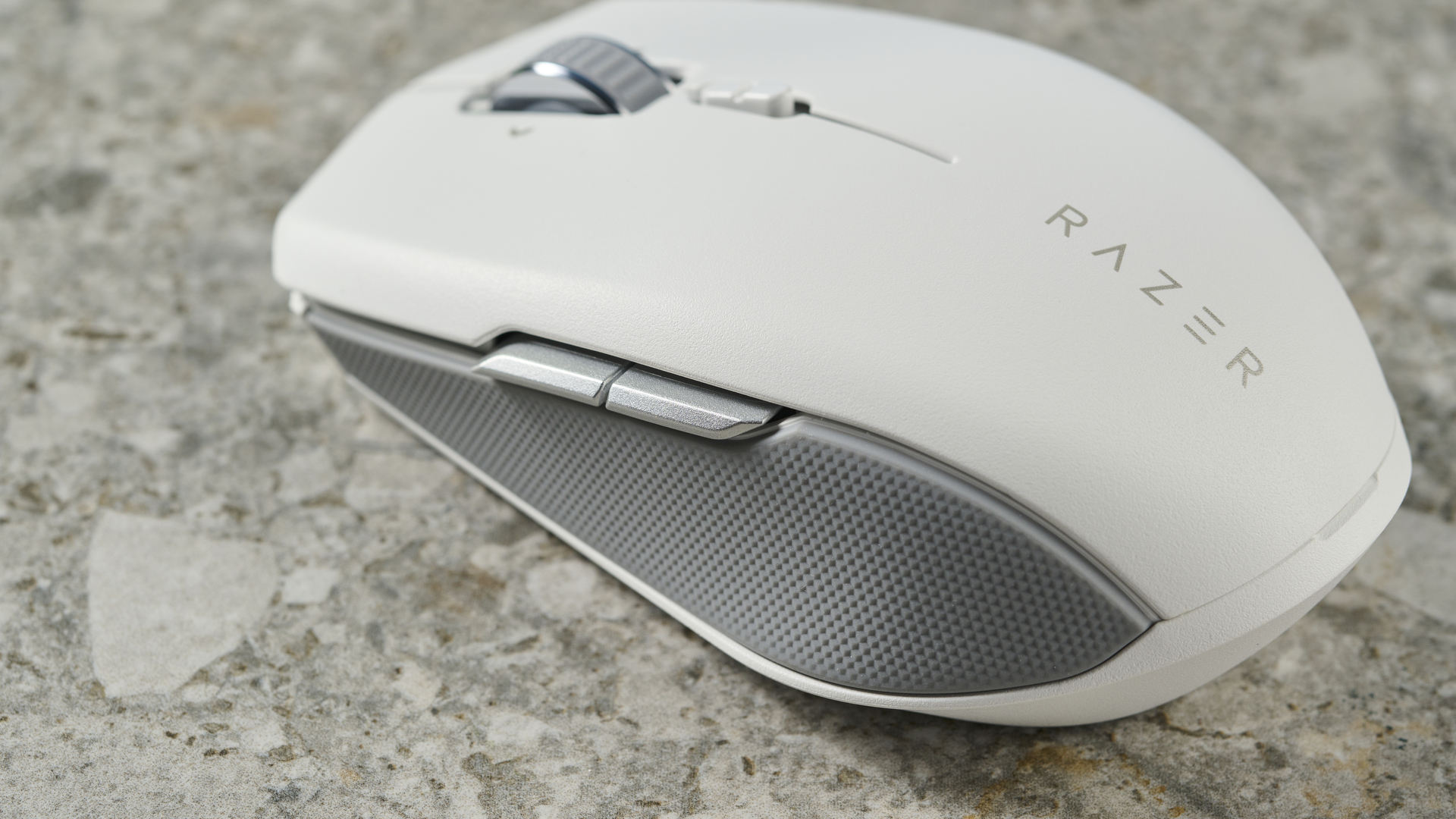 A close-up of the side buttons on a white Razer Pro Click Mini wireless mouse