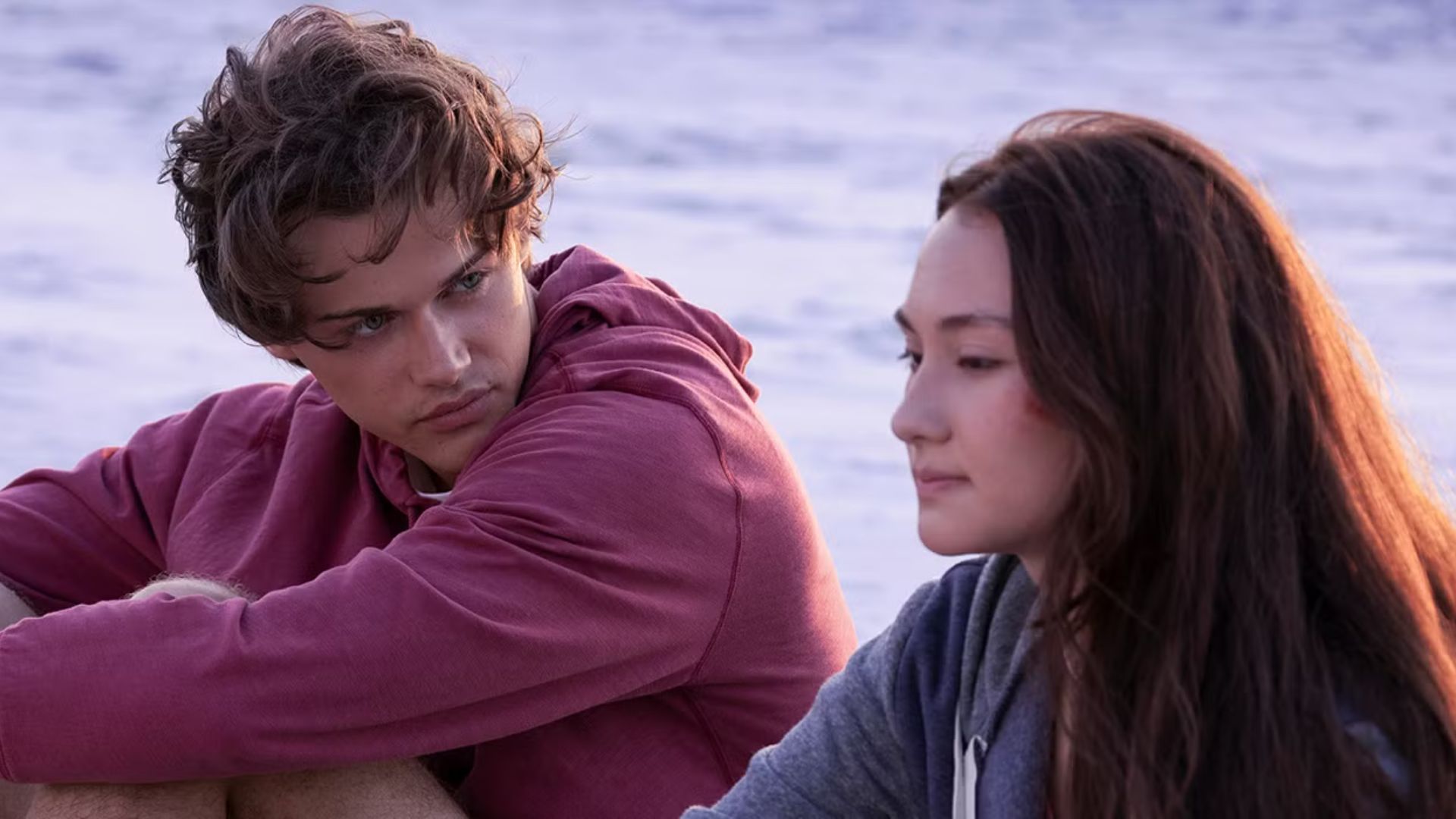 Conrad looks longingly at Belly while sat on the beach