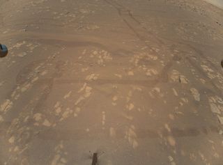 This photo, snapped on April 22, 2021 by NASA's Mars helicopter Ingenuity, shows tracks made by the Perseverance rover on Jezero Crater's floor. “This is the first color image of the Martian surface taken by an aerial vehicle while it was aloft,” NASA officials wrote.