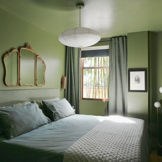 A small bedroom drenched in green paint