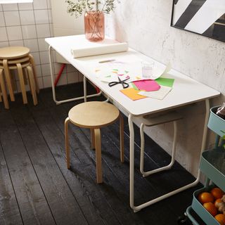 wooden table with chairs and plant on pot with scissor