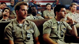 Anthony Edwards and Tom Cruise's Top Gun characters sitting through debriefing with other officers