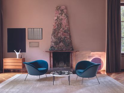 Gio Ponti chairs upholstered in blue velvet and coffee table in front of pink wall with fireplace