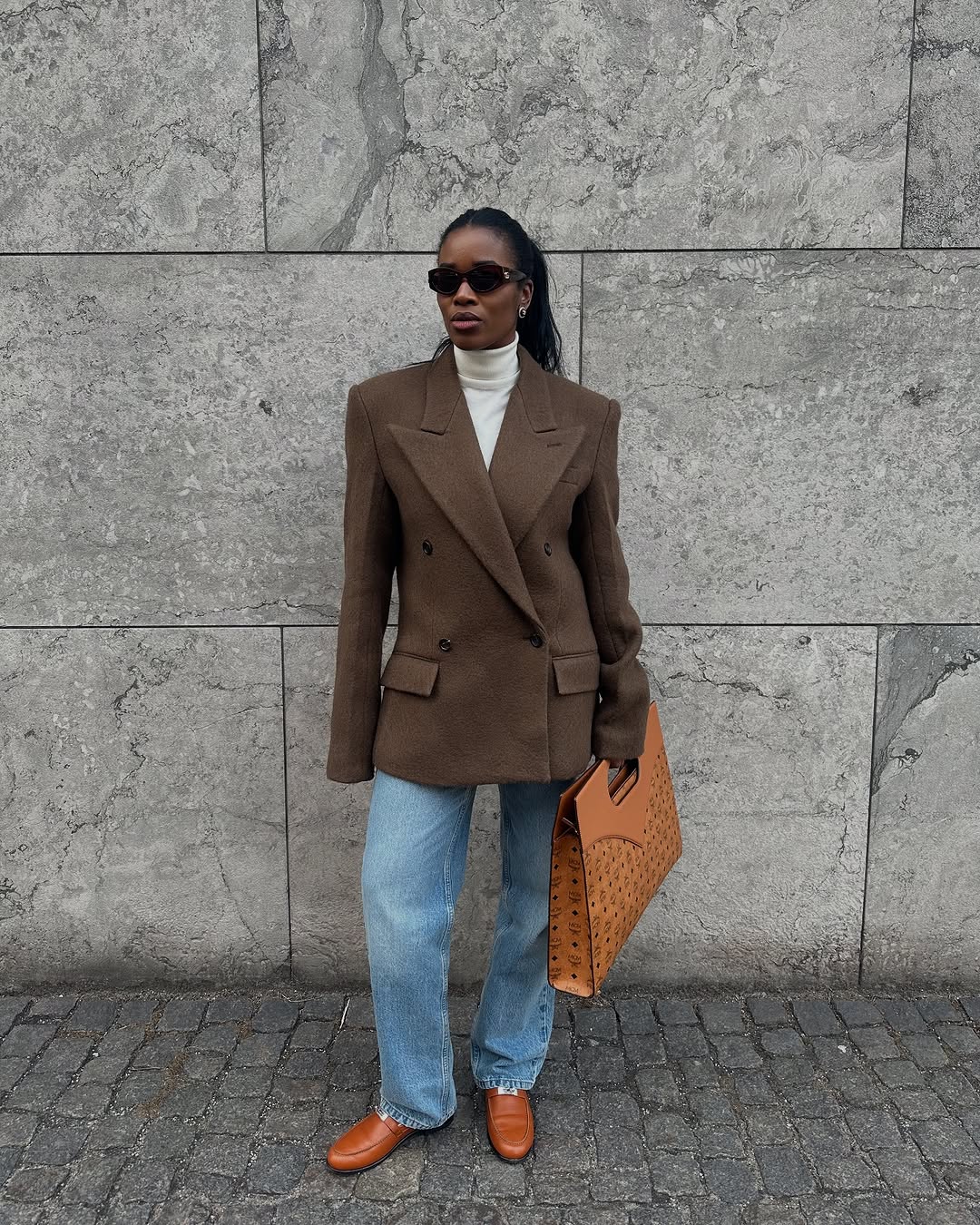 Woman wearing fall blazer with jeans outfit 2025.