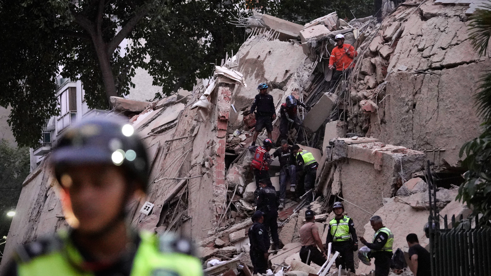 Rescue workers in Venezuela scale rubble of a Caracas building destroyed in powerful back-to-back earthquakes