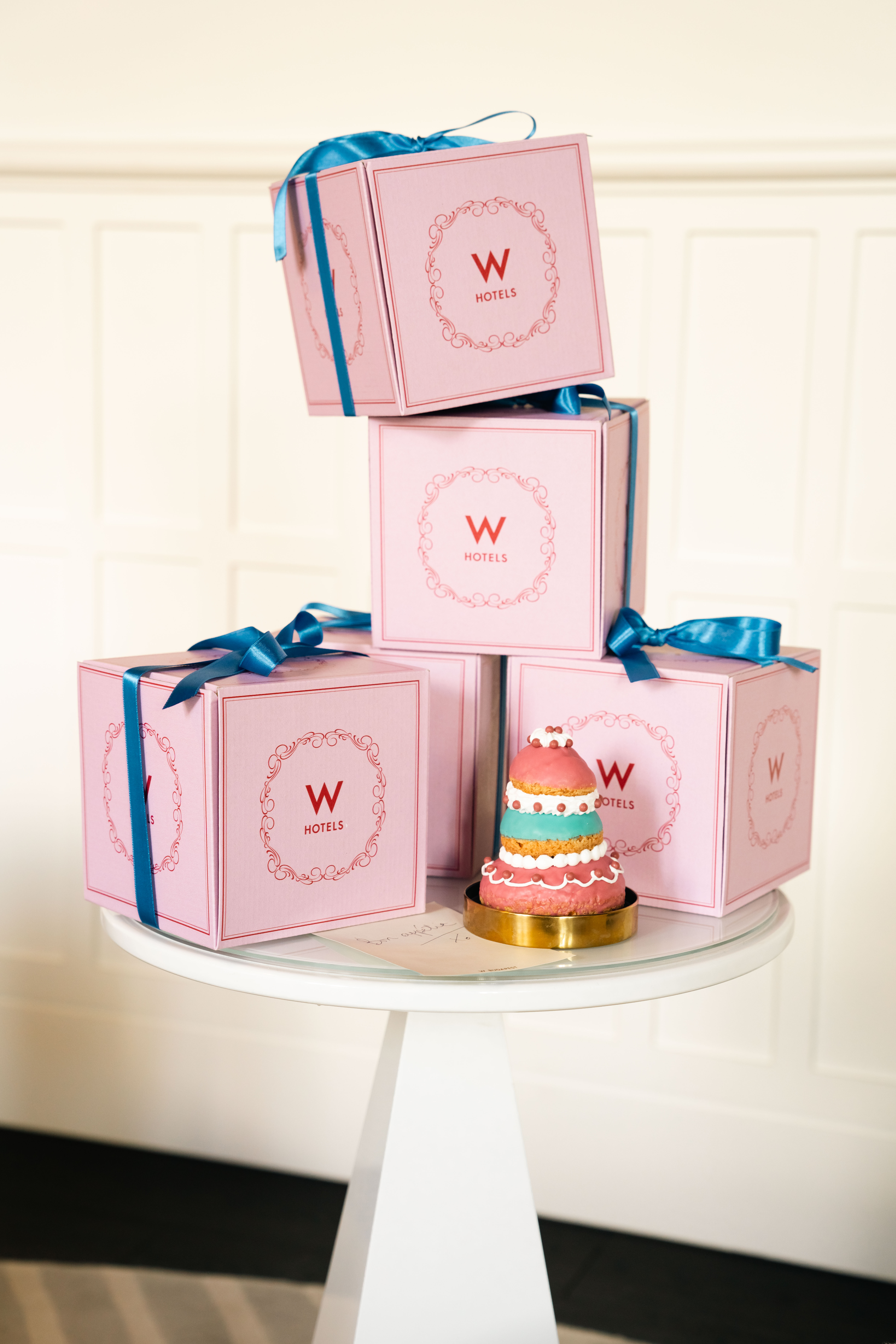 Pink boxes with blue ribbon and a small cake