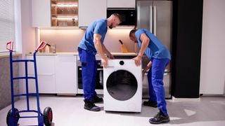 Two men installing a washing machine