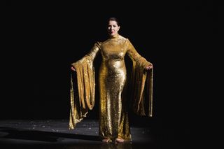 Marina Abramovic wears a sparkly gold dress while performing on stage in her work "7 Deaths Of Maria Callas" in Barcelona