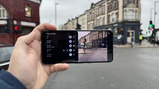 Google Pixel 8 Pro phone being held in front of a building and used to record a video