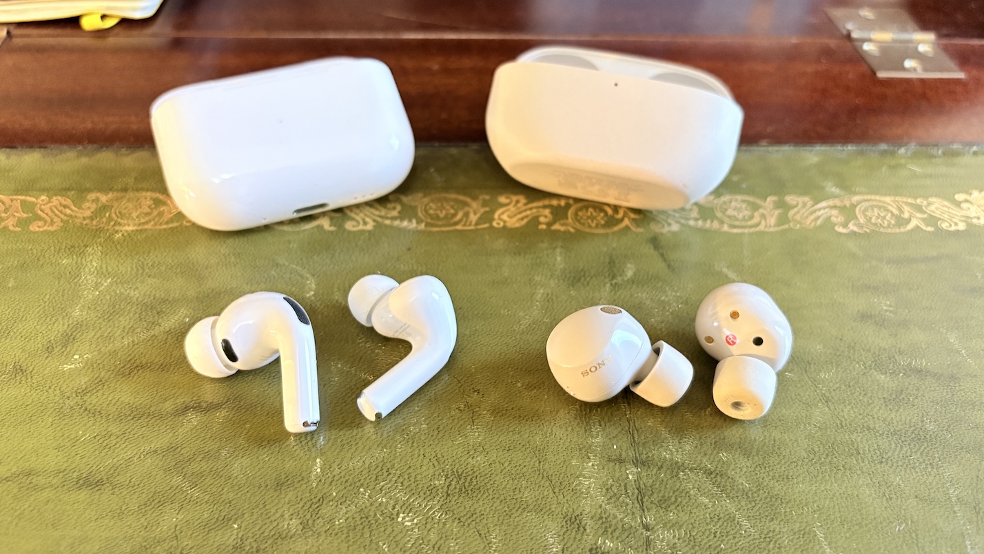 AirPods Pro 3 and Sony WF-1000XM5 earbuds side by side on a green surface with their charging cases.