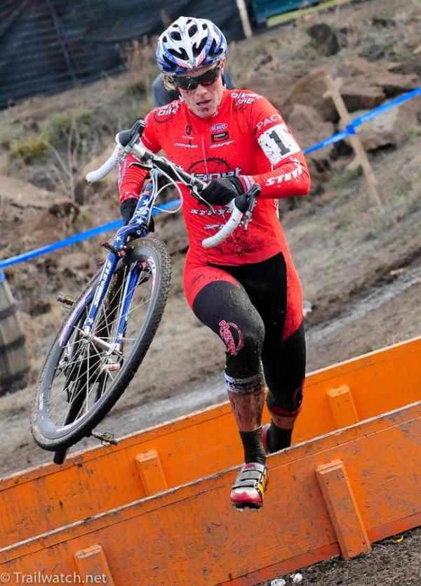 Katie Compton (Planet Bike) sprinting over the barrier at the back of the course.