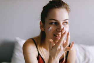 Teenager applying Sudocrem to face