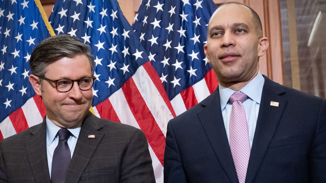 House Speaker Mike Johnson and Minority Leader Hakeem Jeffries stand in front of U.S. flags