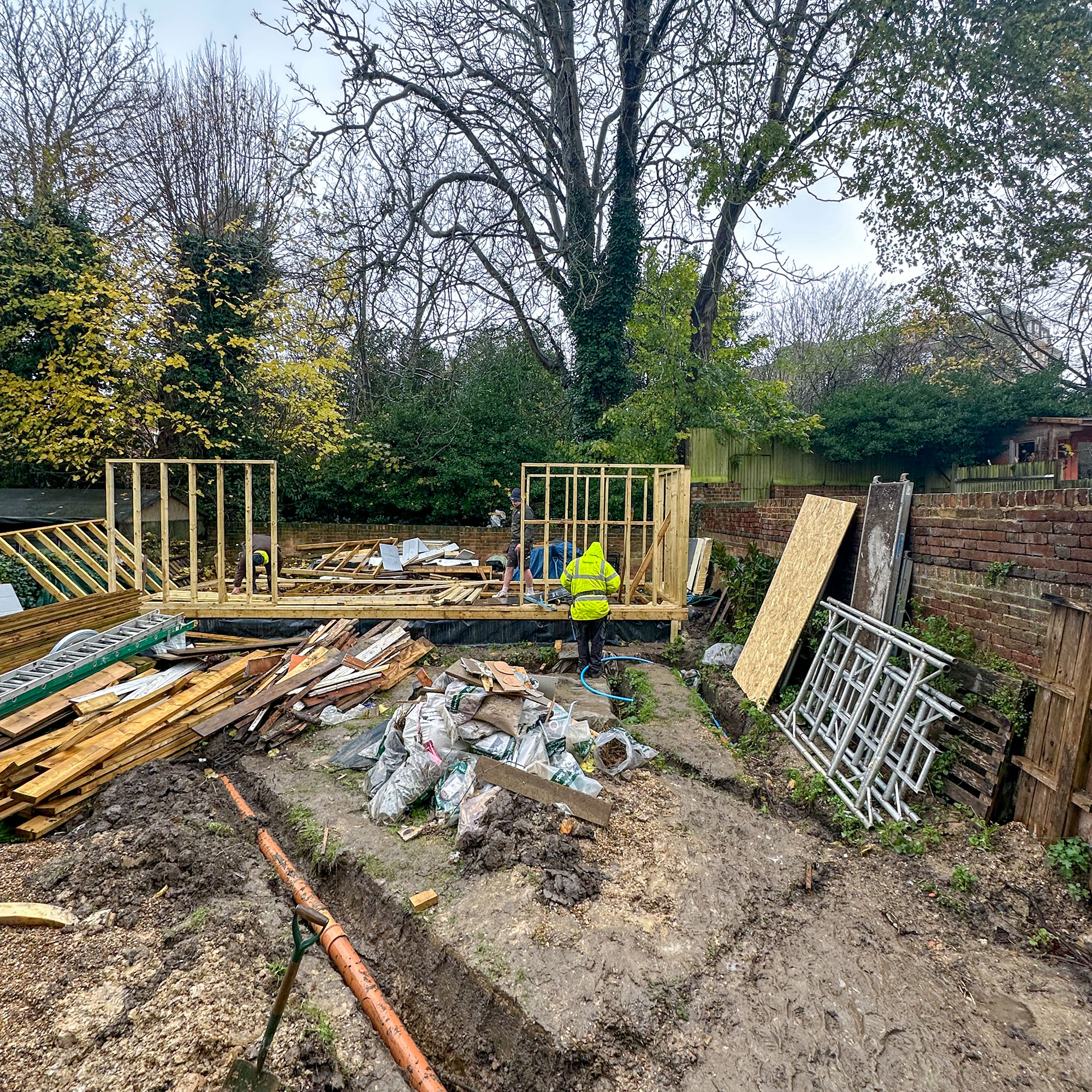 Wooden structure of summerhouse being put up in garden
