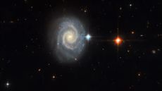 The spiral galaxy MCG-01-24-014 is located 275 million light-years from Earth. Seen face-on, the galaxy has two prominent, well-defined spiral arms and an energetic glowing core known as an active galactic nucleus.