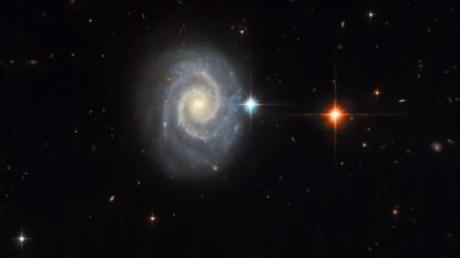 The spiral galaxy MCG-01-24-014 is located 275 million light-years from Earth. Seen face-on, the galaxy has two prominent, well-defined spiral arms and an energetic glowing core known as an active galactic nucleus.