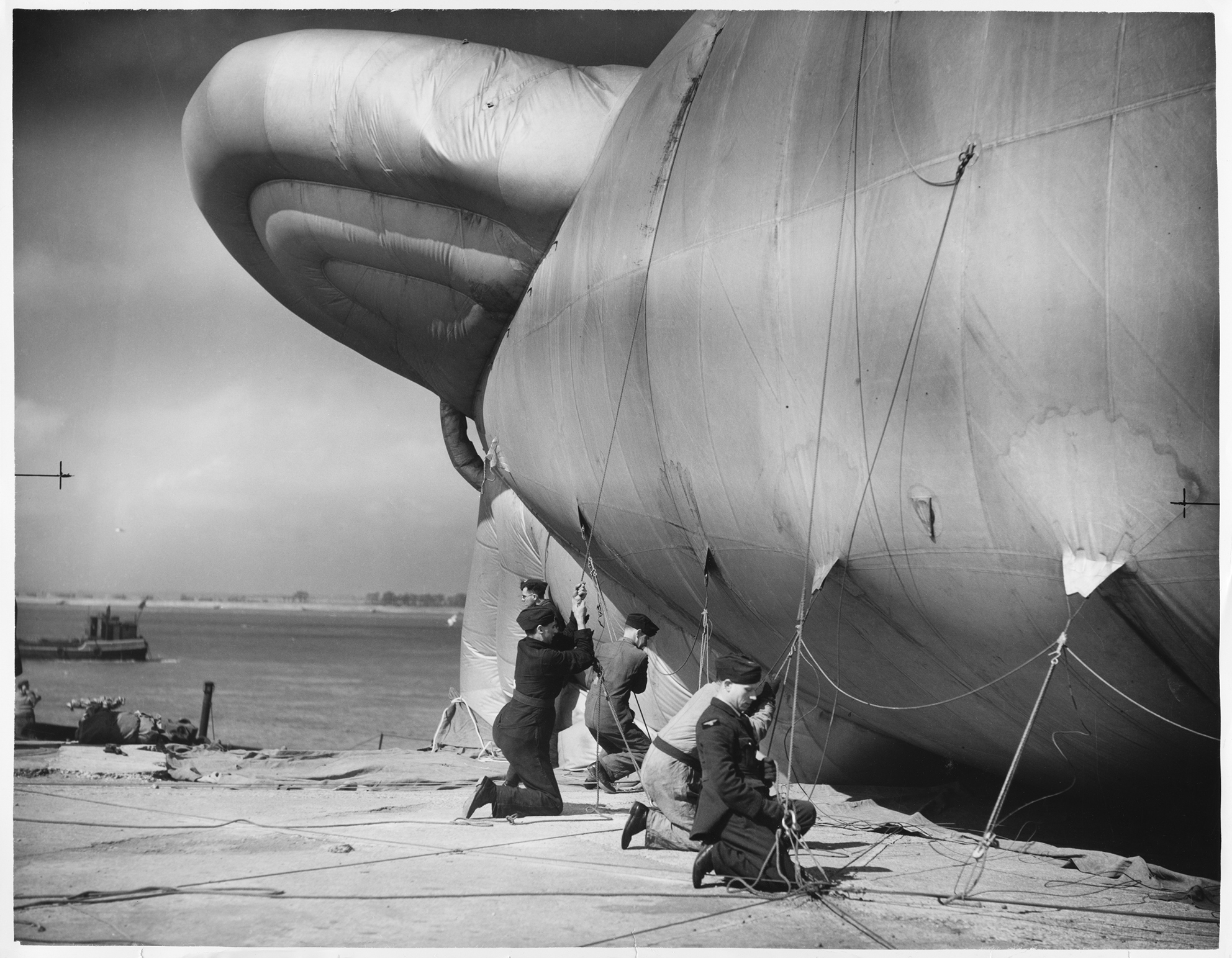 Still from the film 'Operational Height' produced by the RAF Film Production Unit during the Second World War, showing RAF officers tethering a barrage balloon