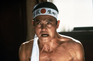 a man with a wrap with japanese text around his head in the movie Mishima: A Life in Four Chapters