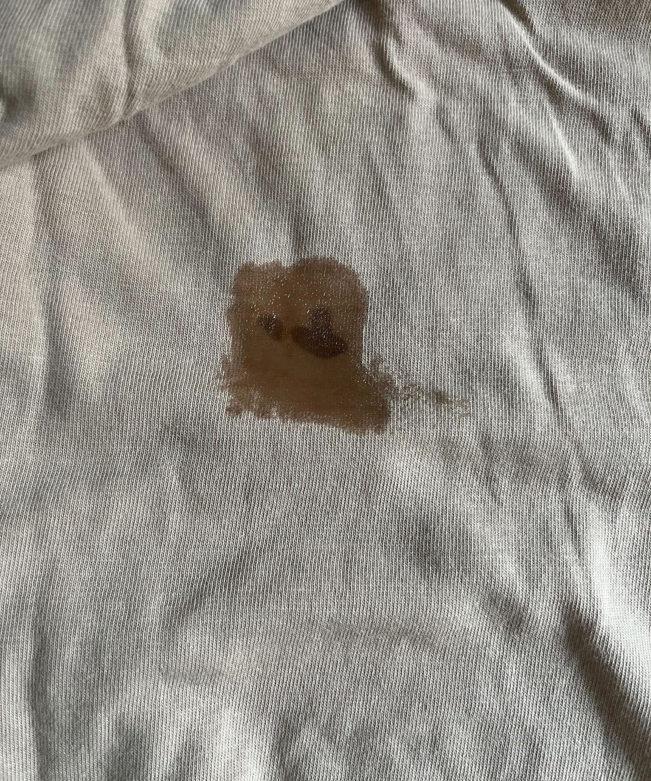 A wet patch over some old blood stains on a beige top