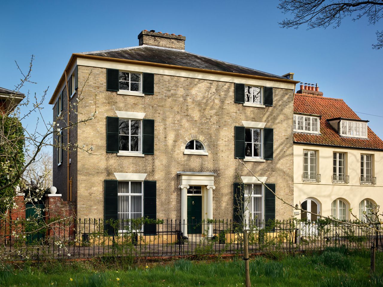 Fig 1: The street frontage of Great House in pale brick, with casements and shutters. The Great House, Dedham. ©Paul Highnam for Country Life.