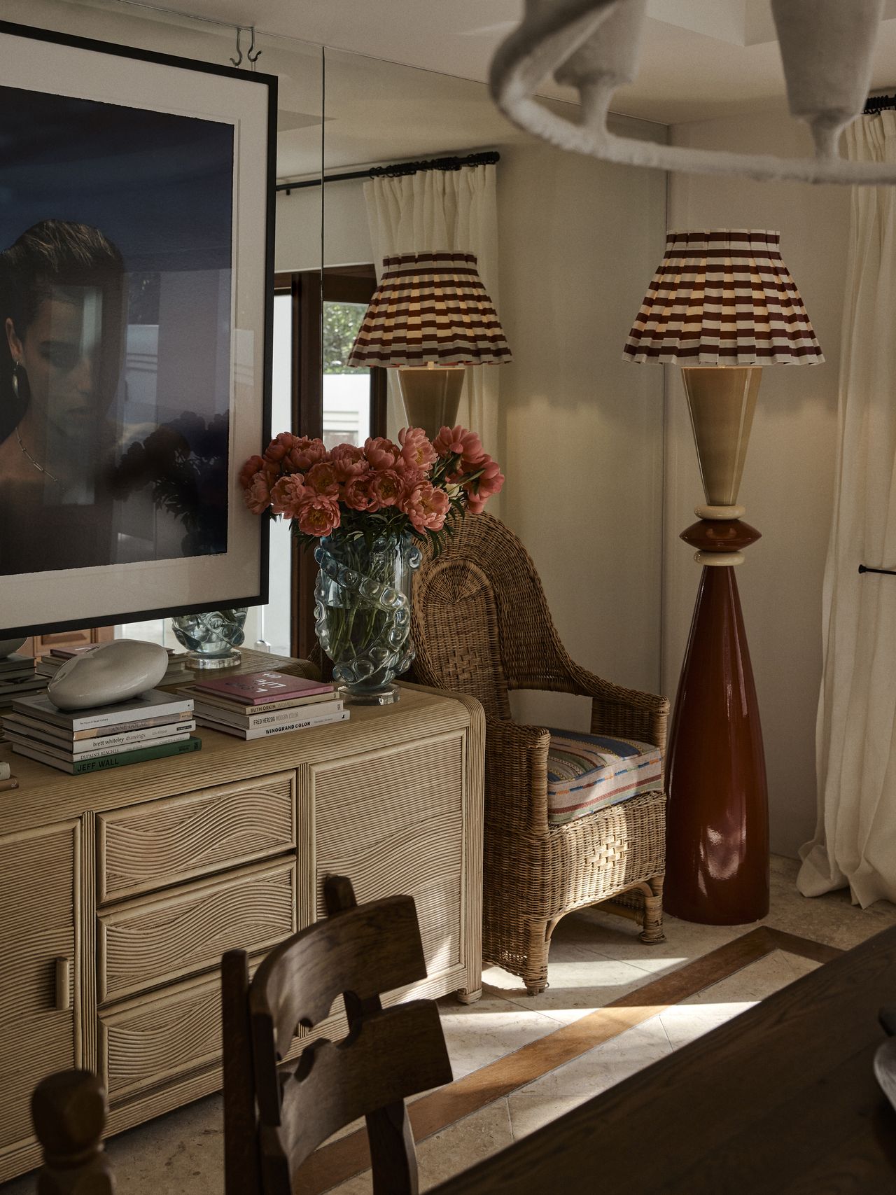 A corner of a communal space with a red striped lamp and natural wicker and wood decor